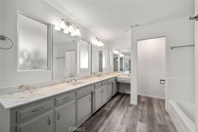 bathroom featuring hardwood / wood-style flooring, vanity, and a bathing tub