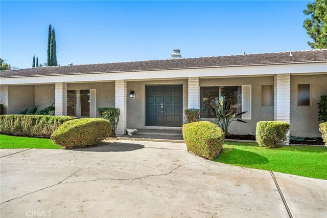 view of exterior entry with a yard