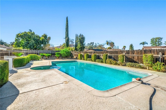 view of swimming pool featuring a patio area, a fenced backyard, and a pool with connected hot tub