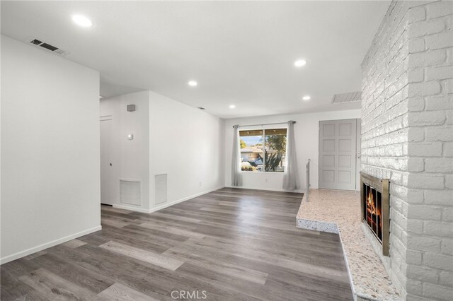 unfurnished living room featuring wood-type flooring and a fireplace