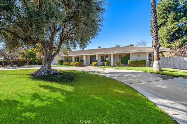 ranch-style home with driveway, a front lawn, and fence