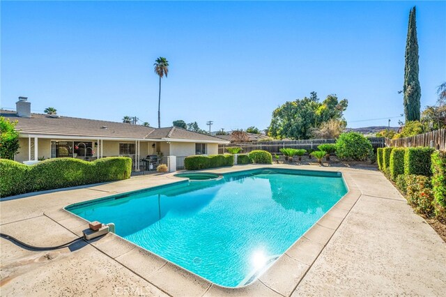 view of swimming pool featuring an in ground hot tub and a patio area