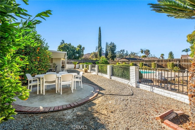 view of patio featuring outdoor dining area, a fenced backyard, and a fenced in pool