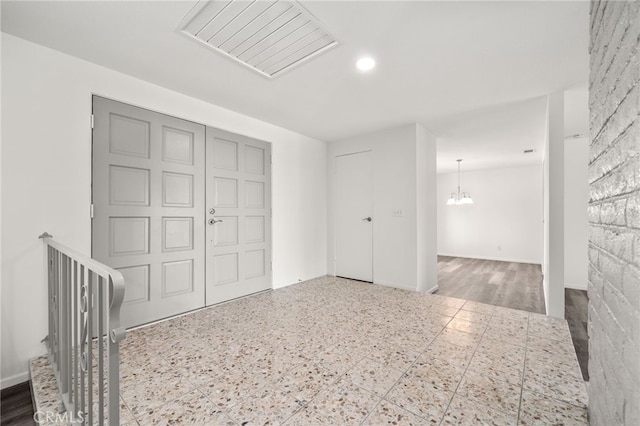 unfurnished bedroom featuring an inviting chandelier, baseboards, visible vents, and a closet