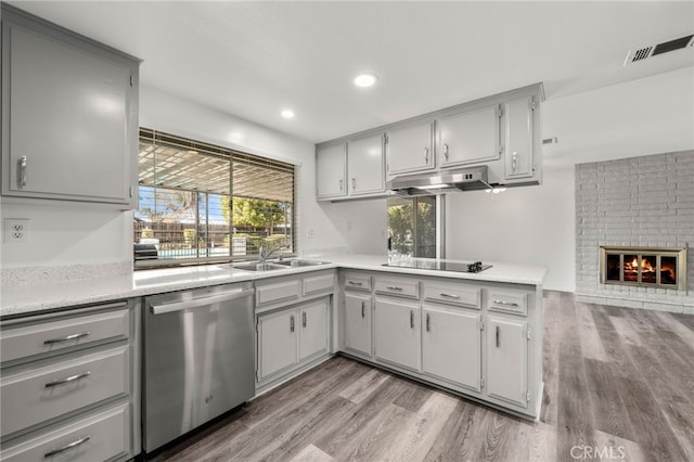 kitchen featuring gray cabinets, a sink, under cabinet range hood, and stainless steel dishwasher