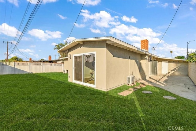 rear view of house with cooling unit and a lawn