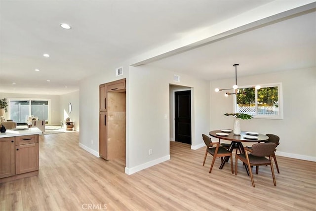 dining room with a notable chandelier and light wood-type flooring