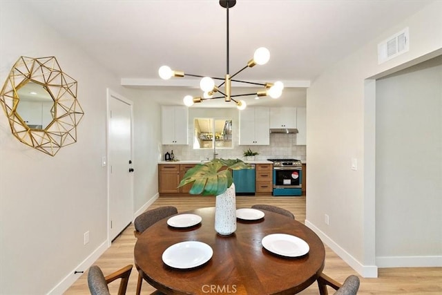 dining space featuring a notable chandelier and light hardwood / wood-style floors