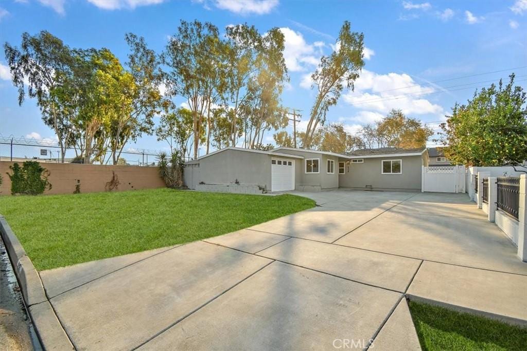 back of house featuring a lawn and a garage