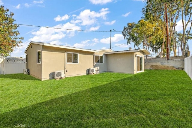 back of property with a lawn and ac unit