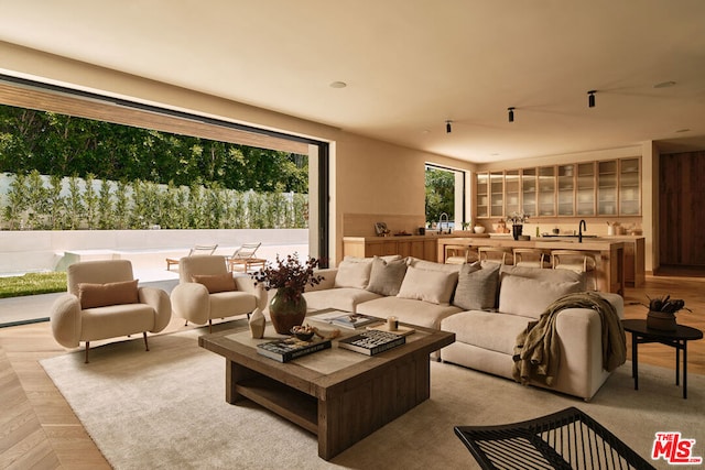 living room featuring light parquet floors and sink