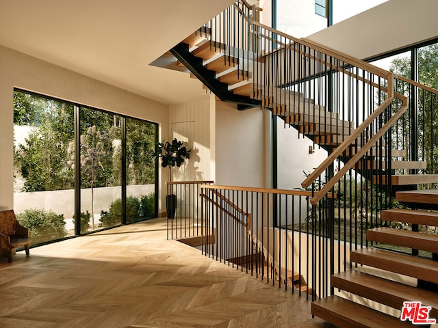 stairway featuring parquet floors