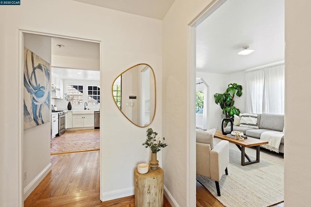 hallway with hardwood / wood-style flooring and sink