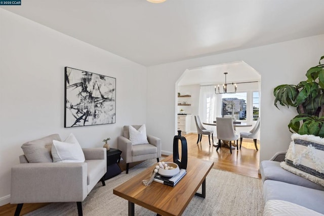 living room featuring light wood-type flooring and a chandelier