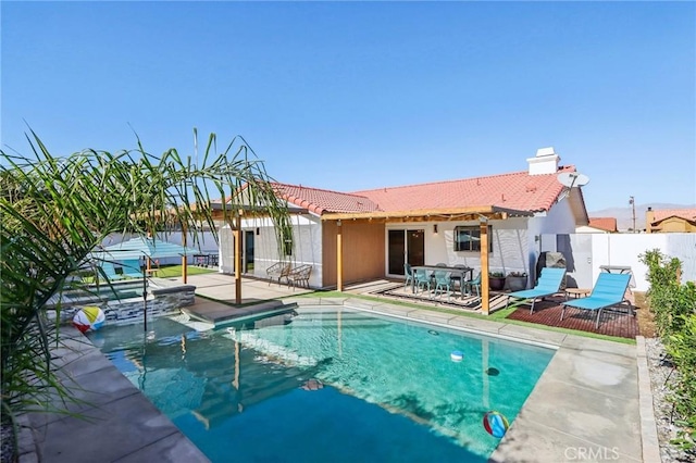 back of property featuring a fenced in pool and a patio area