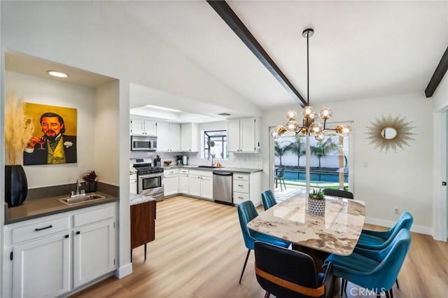 dining area featuring a chandelier, light hardwood / wood-style floors, sink, and vaulted ceiling with beams