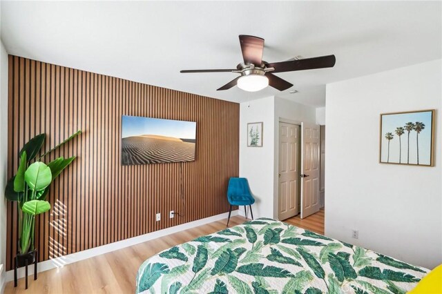 bedroom featuring ceiling fan, baseboards, and wood finished floors