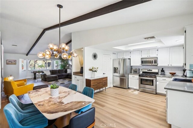 dining space with light wood finished floors, an inviting chandelier, lofted ceiling with beams, and visible vents