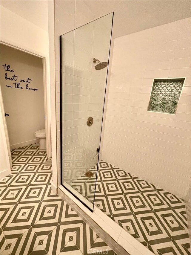 full bath with tile patterned floors, toilet, and a stall shower