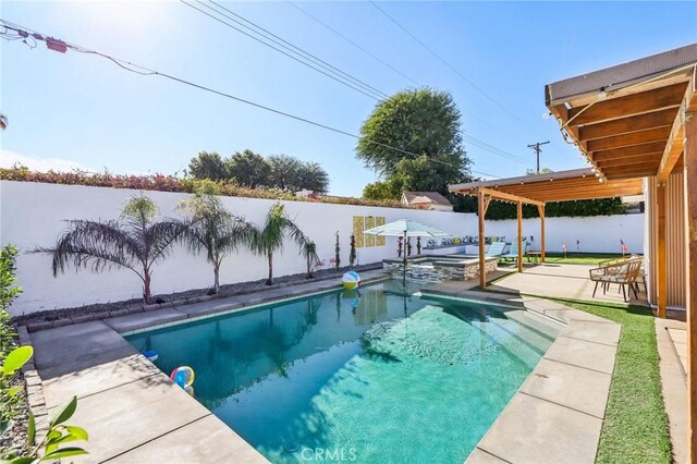 view of swimming pool featuring a patio area, a fenced backyard, and a pool with connected hot tub