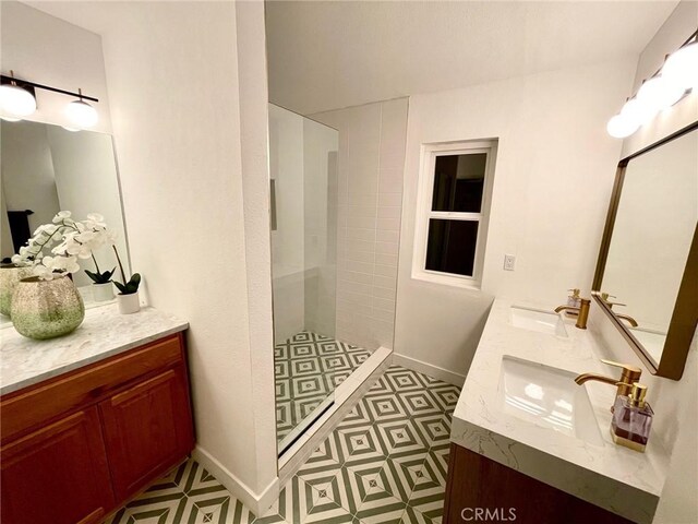 full bath featuring a walk in shower, double vanity, baseboards, and a sink
