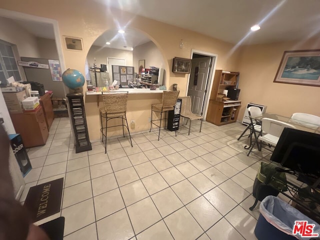 kitchen with a kitchen breakfast bar, light tile patterned floors, and kitchen peninsula