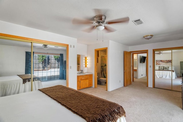 bedroom featuring sink, ensuite bath, ceiling fan, access to exterior, and light colored carpet