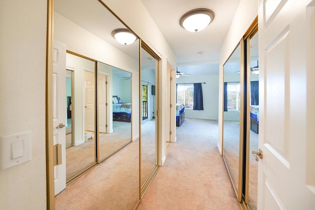 hallway featuring light colored carpet