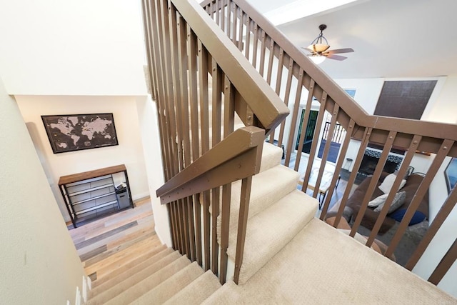 stairway featuring ceiling fan and wood-type flooring