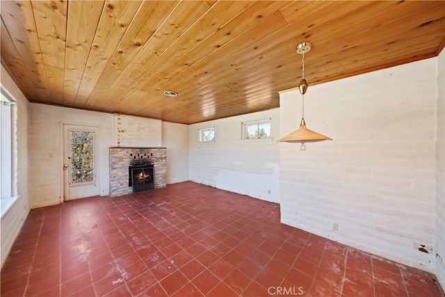 unfurnished living room featuring brick wall, wood ceiling, and a fireplace