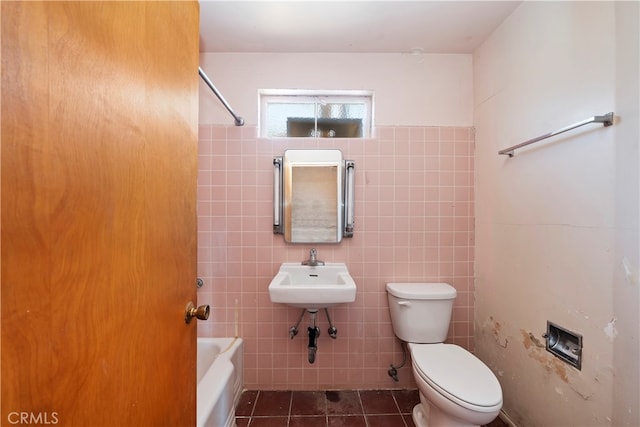 bathroom featuring sink, tile walls, and toilet