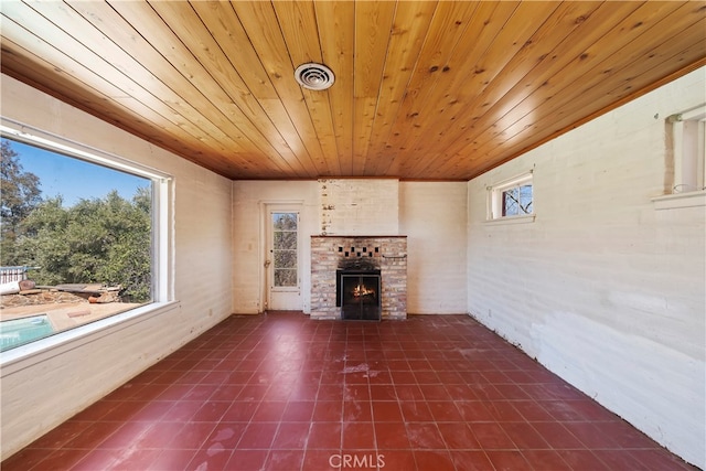 unfurnished living room featuring a brick fireplace and wood ceiling