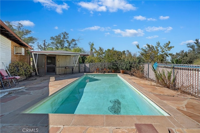 view of swimming pool with a wall unit AC and a patio