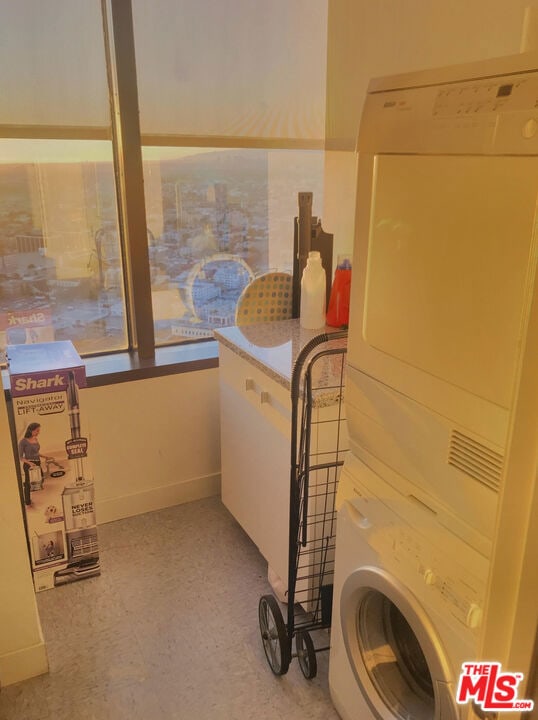 bathroom featuring stacked washer / drying machine