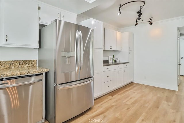 kitchen featuring white cabinetry, light wood-type flooring, light stone countertops, ornamental molding, and stainless steel appliances