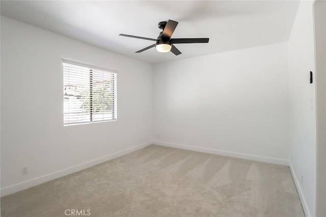 carpeted spare room featuring ceiling fan