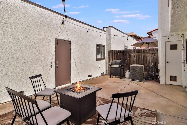 view of patio featuring an outdoor fire pit, grilling area, and central AC