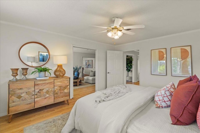 bedroom featuring hardwood / wood-style flooring, ornamental molding, and ceiling fan