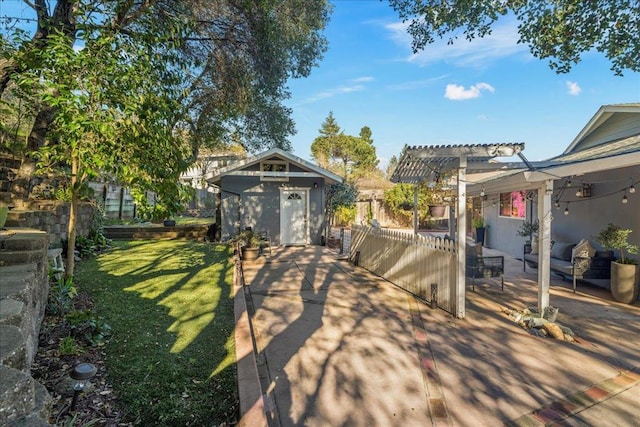 view of yard featuring a pergola, a patio, and a storage unit