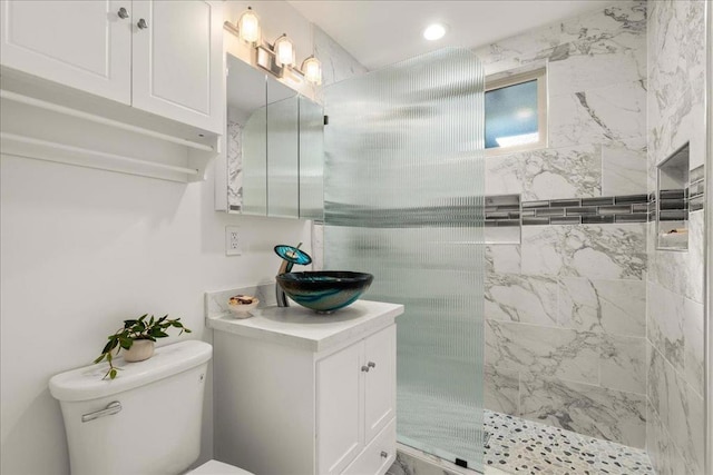 bathroom featuring vanity, toilet, and tiled shower