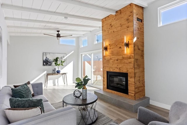 living room featuring wood ceiling, ceiling fan, hardwood / wood-style floors, a fireplace, and beamed ceiling