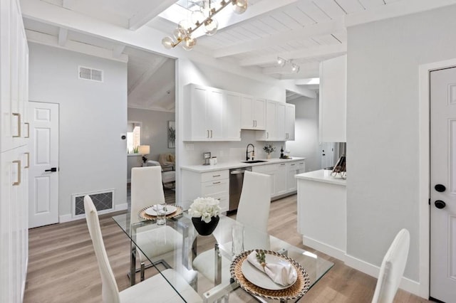 dining room with sink, wood ceiling, vaulted ceiling with beams, a chandelier, and light wood-type flooring