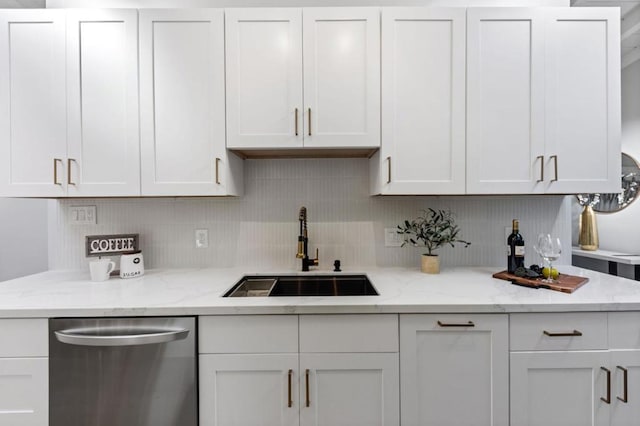 kitchen featuring sink, stainless steel dishwasher, white cabinets, and light stone countertops