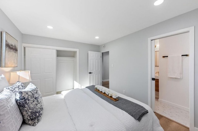 bedroom with wood-type flooring, ensuite bath, and a closet