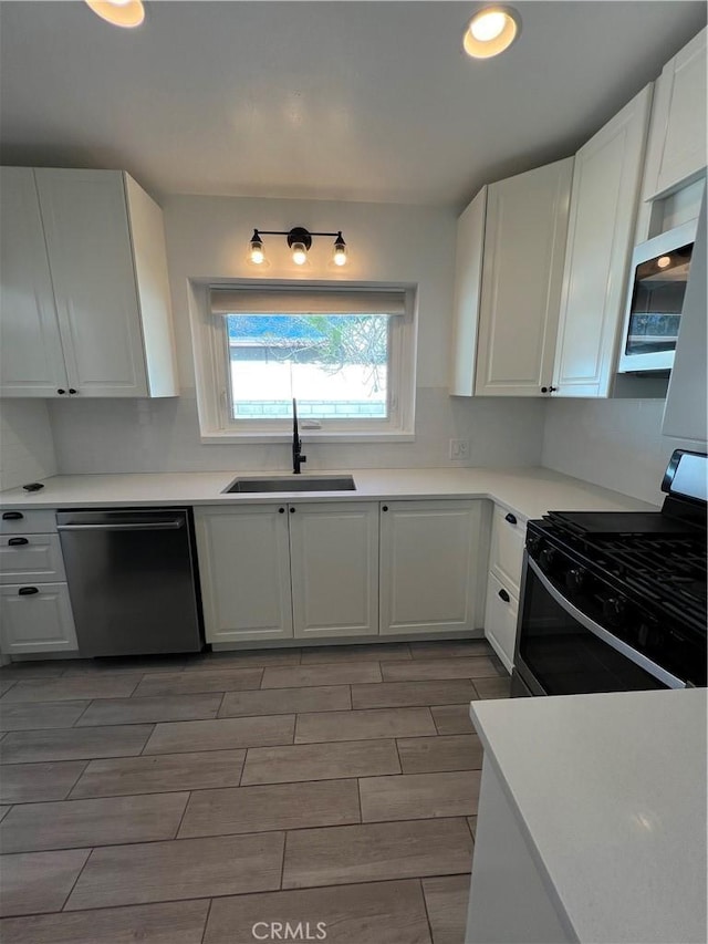 kitchen featuring stainless steel appliances, white cabinets, and sink