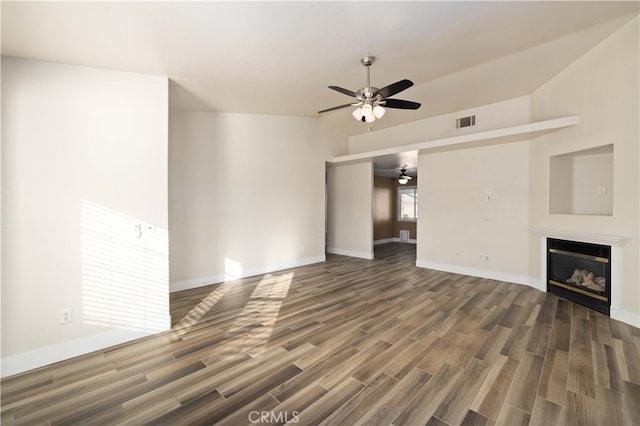 unfurnished living room featuring ceiling fan and dark hardwood / wood-style flooring