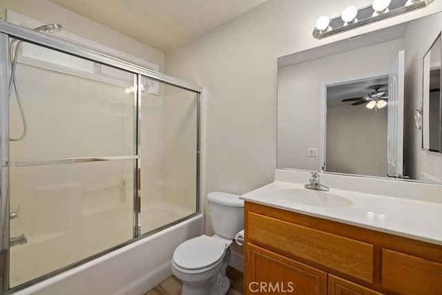 full bathroom with ceiling fan, enclosed tub / shower combo, vanity, and toilet