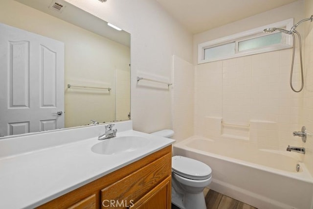 full bathroom with toilet, hardwood / wood-style flooring, vanity, and shower / bathing tub combination