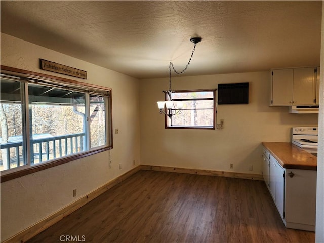 unfurnished dining area with a textured ceiling, dark hardwood / wood-style floors, and a chandelier
