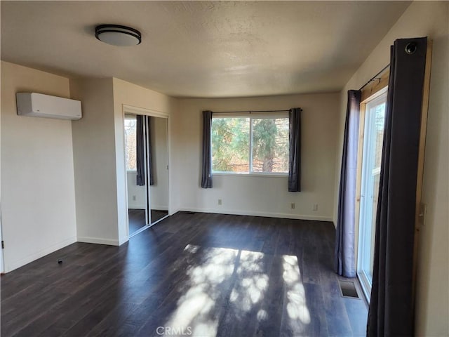 interior space featuring an AC wall unit and dark hardwood / wood-style floors